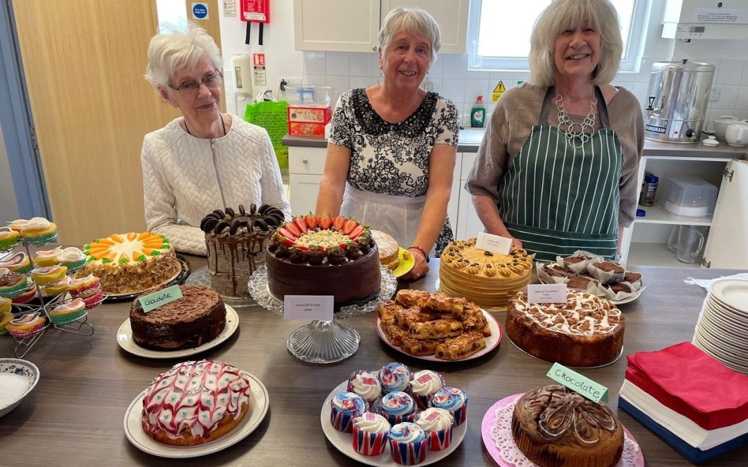 Three ladies serving tea and cake